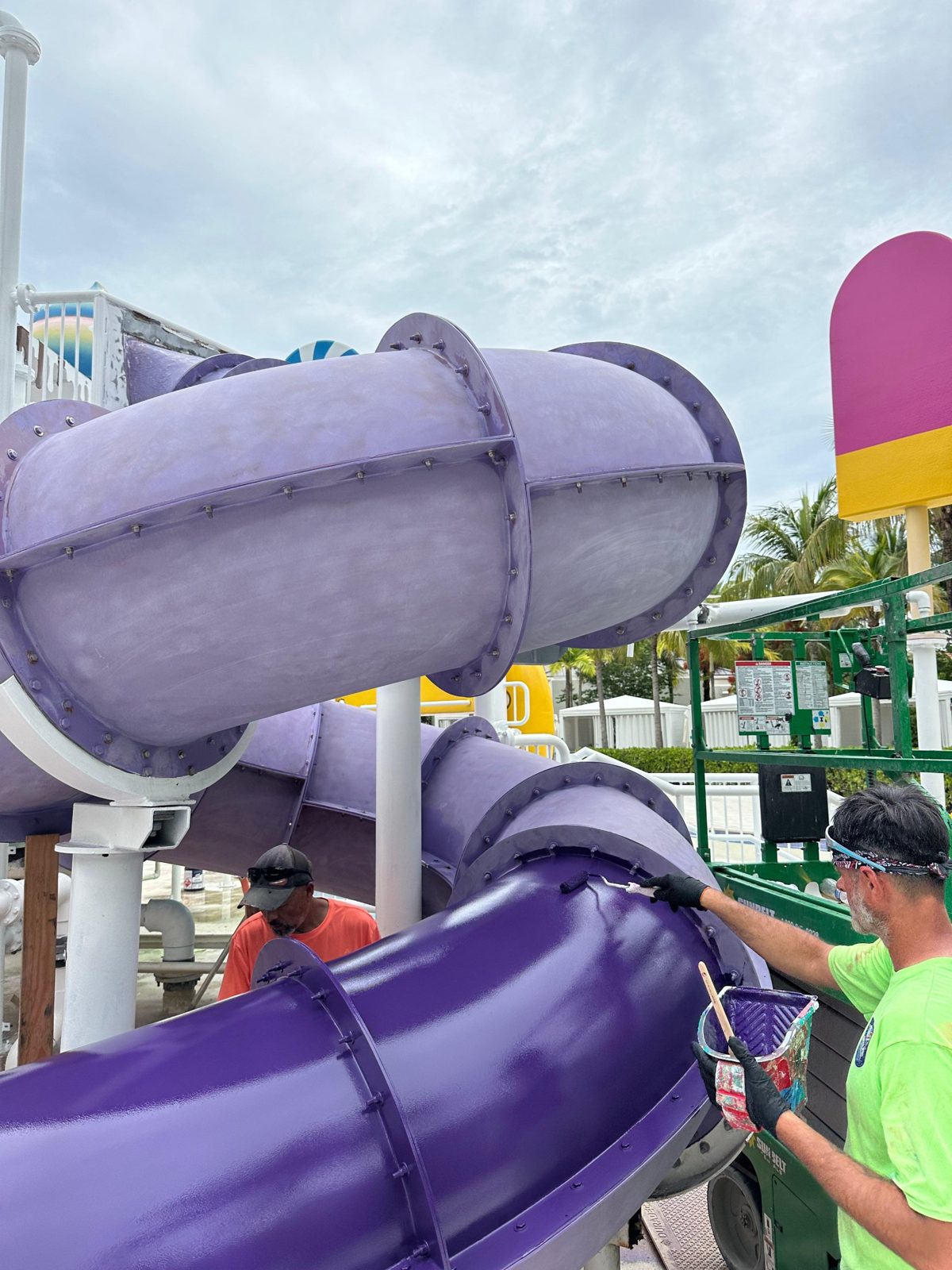 Crew rolling fresh purple coating onto a faded slide section