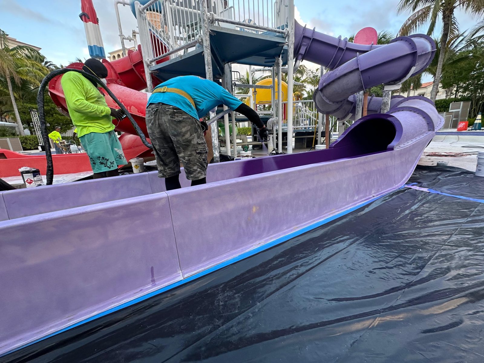 Crew spraying the inside of a purple slide runout