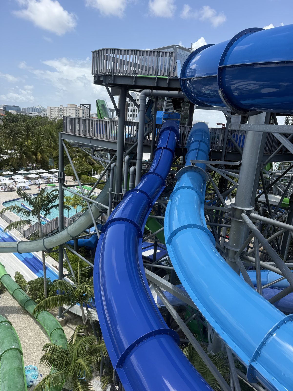 Two blue slides leaving the tower with the pools below